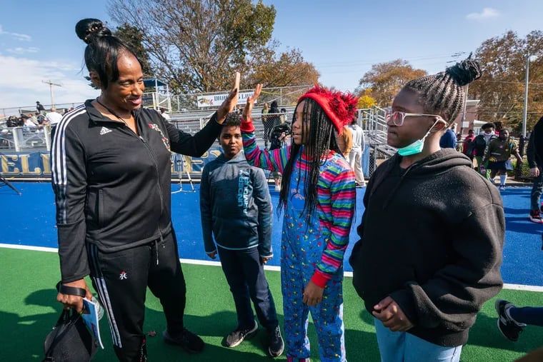 Olympic legend Jackie Joyner-Kersee high-fives student Victoria Brown, as Tatyana Henderson, right front, and Hasan Moussa, back center, look on. Joyner-Kersee met with more than 200 students from Alain Locke School at the Vidas Athletics Complex on Monday.