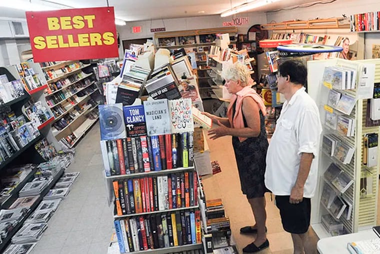 Liz McCaffrey looks at a book while husband Joe Serritella waits at The Paper Peddler in Avalon Sept. 9, 2014. The store has been a fixture in Avalon since 1968 but will be closing at the end of September 2014.   ( CLEM MURRAY / Staff Photographer )