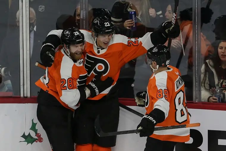 Flyers Oskar Lindblom, center celebrates his goal against the Devils with teammates Claude Giroux, left and Cam Atkinson right, during the second period at the Wells Fargo Center in Philadelphia, Tuesday, December 14 2021.