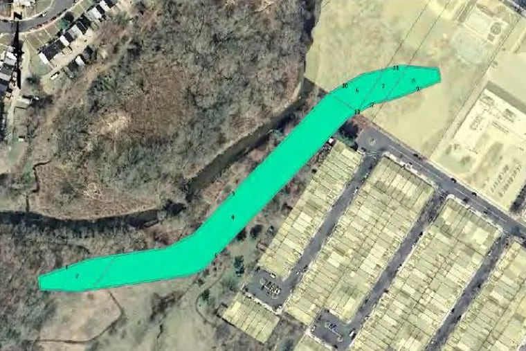 A U.S. Army Corps of Engineers proposal calls for building a nearly 1,400 foot long, 15 foot high earthen levee along the banks of Cobbs Creek in Philadelphia's Eastwick section. One of the possible  placements for the levee is shown in green with the creek on one side, and homes on the other. An alternative calls for a slightly different alignment for the levee.