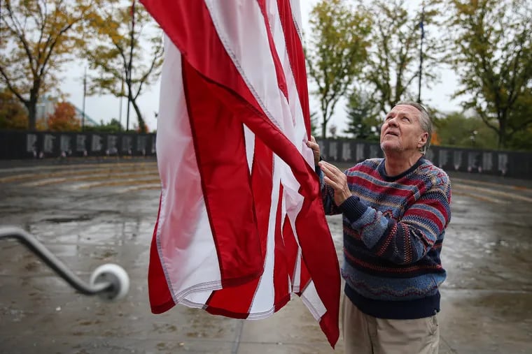 Jim Moran, 75, who is the volunteer caretaker for the Philadelphia Vietnam Veterans Memorial, inspects the American flag at the memorial.