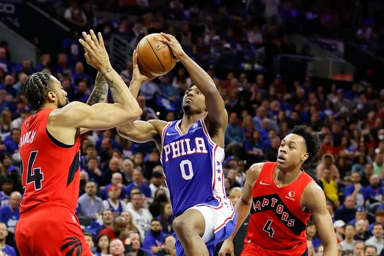 Sixers guard Tyrese Maxey drives to the basket against Toronto Raptors center Khem Birch (left) and forward Scottie Barnes during game one in the Eastern Conference quarterfinals playoffs on Saturday, April 16, 2022 in Philadelphia.