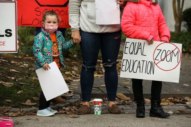 Elyse Singer, 3, Jennifer Singer, and Abby Singer, 8, stand outside the home of Montgomery County Commissioners Chair Val Arkoosh to protest the county's decision to close all K-12 schools for two weeks beginning Nov. 23.