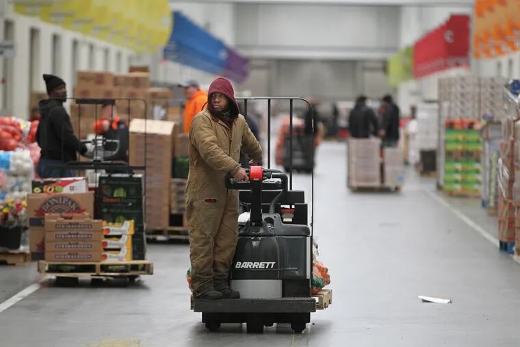 A forklift operator navigates the main thoroughfare of the Food Distribution Center as he deliveries a load of potatoes.
