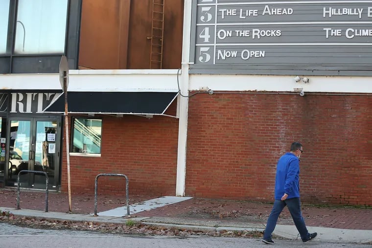 A pedestrian walks by the marquee of the Ritz movie theater on Walnut Street in Philadelphia, Pa. on November 16, 2020. Philadelphia will shut down indoor dining, gyms, and museums, and ban public and private gatherings, starting Friday and lasting through Jan. 1, officials said Monday as the number of new coronavirus cases in Pennsylvania and New Jersey soar.