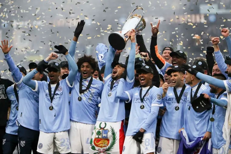 New York City FC players celebrate with the trophy.