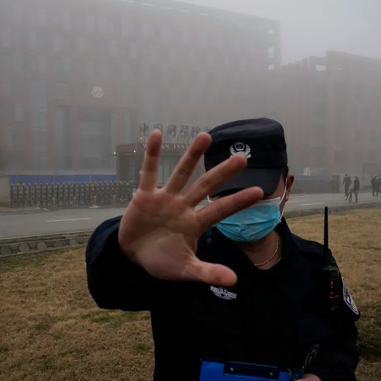 A security person moves journalists away from the Wuhan Institute of Virology after a World Health Organization team arrived for a field visit in Wuhan in China's Hubei province on Feb. 3, 2021.