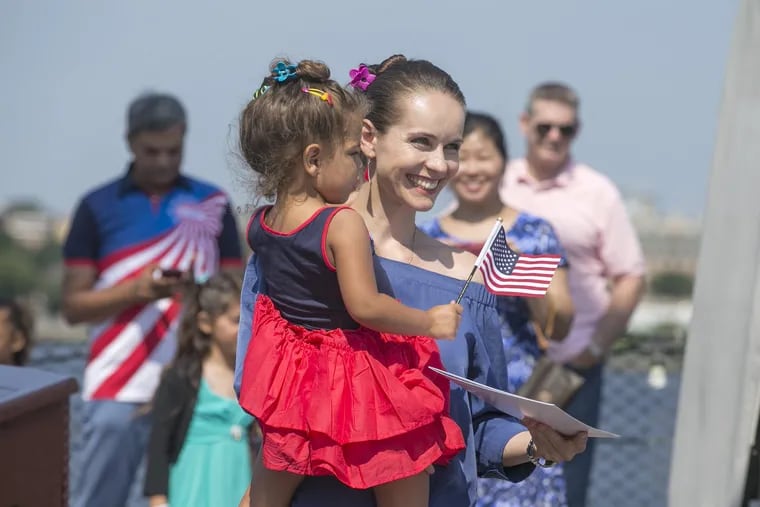 On July 4, 2017, 47 candidates from 33 countries became naturalized U.S. citizens after taking the Oath of Allegiance onboard the battleship New Jersey in Camden. Here, carrying her 3 year old daughter Olivia, Polish born Hanna Pawlowska smiles after receiving her citizenship. 