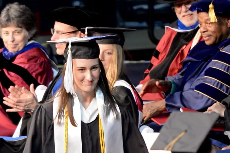 Rachel Hall, injured in a hit-run, crosses the stage at the commencement ceremony. Her mother had picked up her diploma last year.