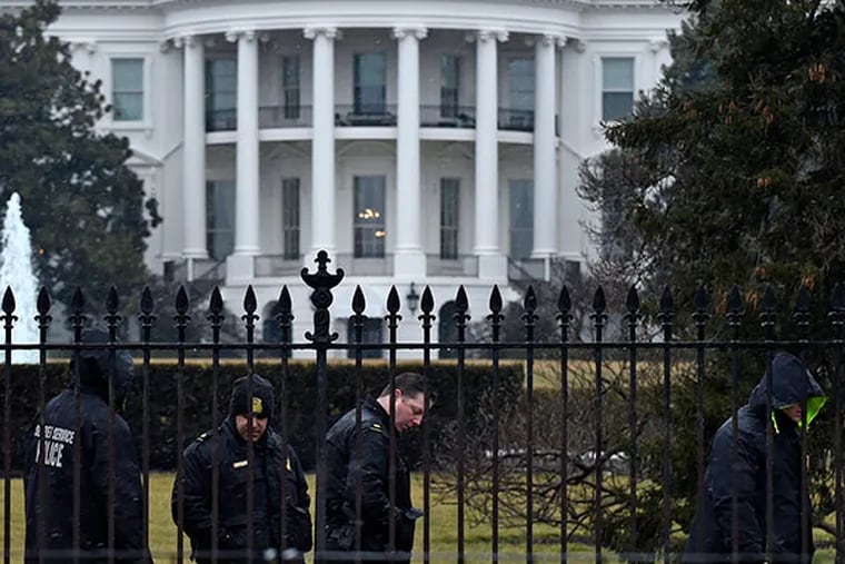 Secret Service officers search the south grounds of the White House on Monday. SUSAN WALSH / Associated Press