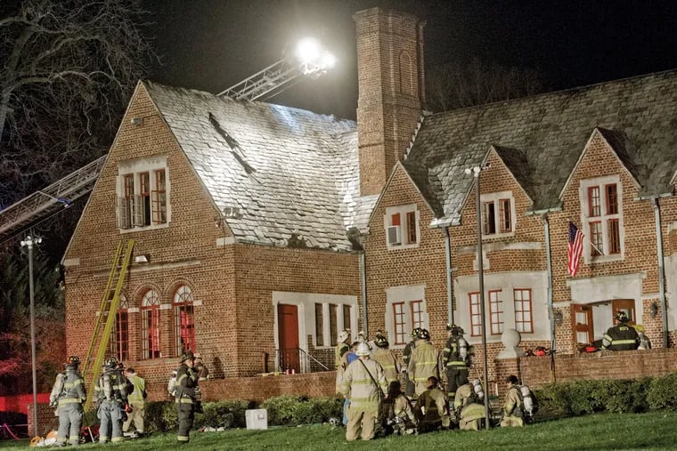 Firefighters inspect the roof of the Moorestown Community House for damage after a fire at the 90-year-old landmark Tuesday. No injuries were reported.
