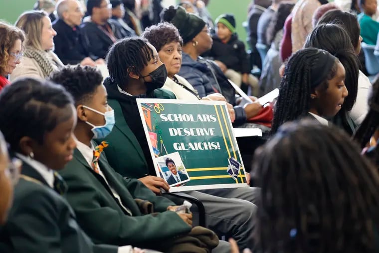 Global Leadership Academy students sit with their sign during a School District of Philadelphia board meeting on Thursday.