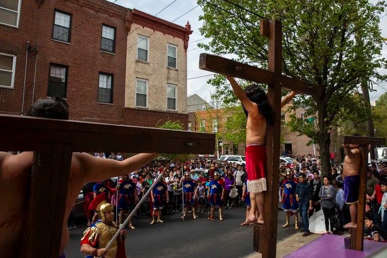 Eduardo Lazaro, center, portrays Jesus during the crucifixion stage of the Stations of the Cross procession outside of the Annunciation BVM Church in South Philadelphia on Friday, April 19, 2019.
