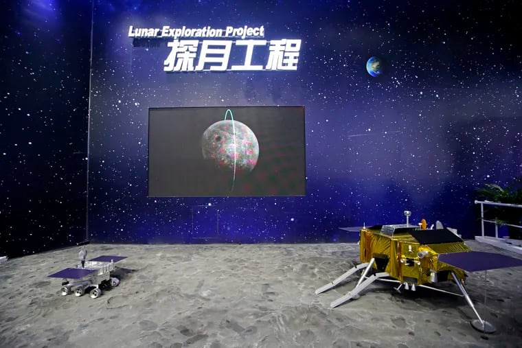 In this file photo taken Wednesday, Nov. 7, 2018, models of Chinese Chang'e IV Relay Satellite, right, and Lunar Probe Consists are displayed during the 12th China International Aviation and Aerospace Exhibition, also known as Airshow China 2018, in Zhuhai city, south China's Guangdong province.