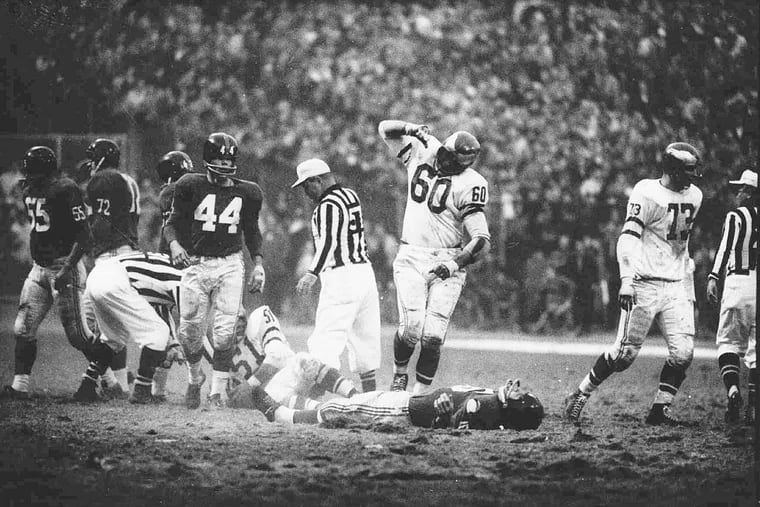 This was the scene Nov. 20, 1960 as gesturing Eagles linebacker Chuck Bednarik (60) stood over unconscious Frank Gifford after making a hard tackle of the Giants halfback at Yankee Stadium. The impact caused Gifford to fumble, and sent him to a hospital. The ball was recovered by Chuck Weber (51), another Eagles linebacker.