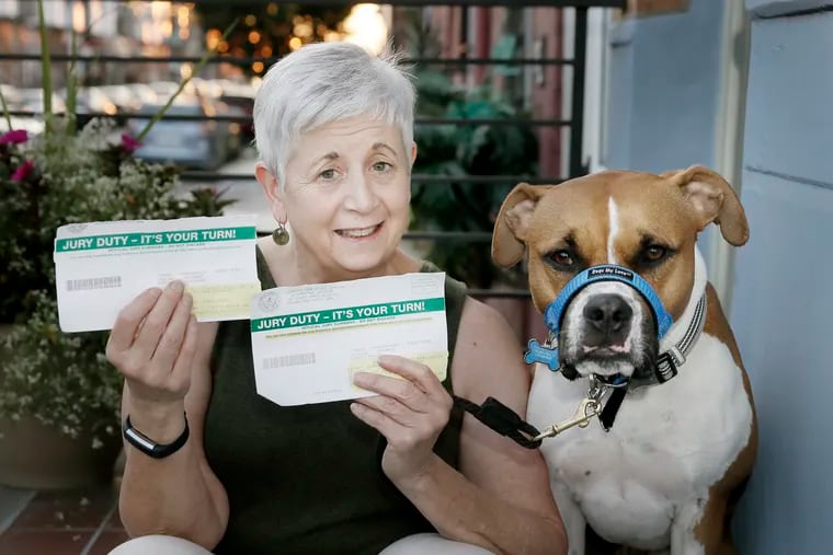 Carol Brodie-Mackin sits with her dog Junior, and the two jury duty notices she received in May, on the front steps of her South Philadelphia home on Aug. 23, 2018.