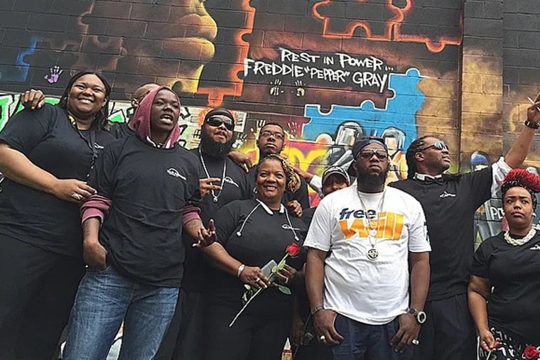 Rapper Freeway, Heal A Woman Heal A Nation volunteers and members of Freddie Gray's community at the site of Gray's new memorial mural (1649 N. Fulton Street, Baltimore). (Instagram / @phillyfreeway)