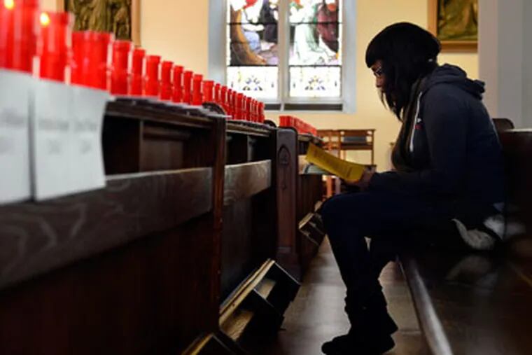 Samantha Tunsil, 25, visits the Cathedral of the Immaculate Conception in Camden on Thursday, during a three-day vigil in honor of the city's homicide victims during the year. She'd just heard about the vigil, and came to honor a friend of a cousin, Hanief Bailey, who was shot and killed in the Whitman Park neighborhood of Camden over the Thanksgiving weekend.