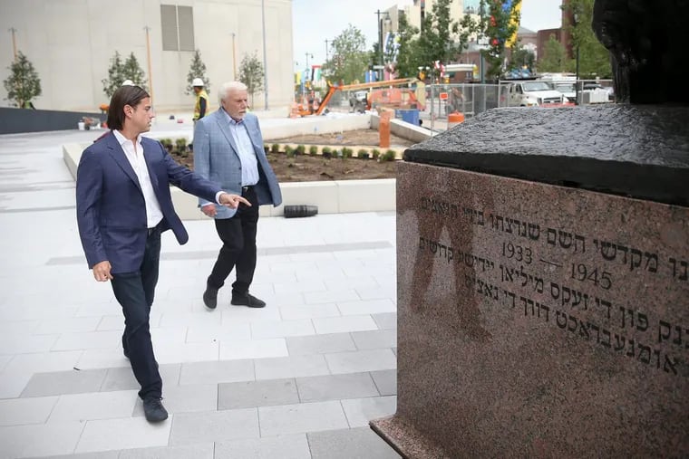 David Adelman, left, CEO of Campus Apartments and chairman of the Philadelphia Holocaust Remembrance Foundation, and Alan Horwitz, chairman of Campus Apartments and a donor to the new Holocaust Memorial Plaza along the Benjamin Franklin Parkway, talk about features of the new memorial plaza. The renovated plaza includes the existing Monument to the Six Million Jewish Martyrs, visible at right, which was installed in 1964.