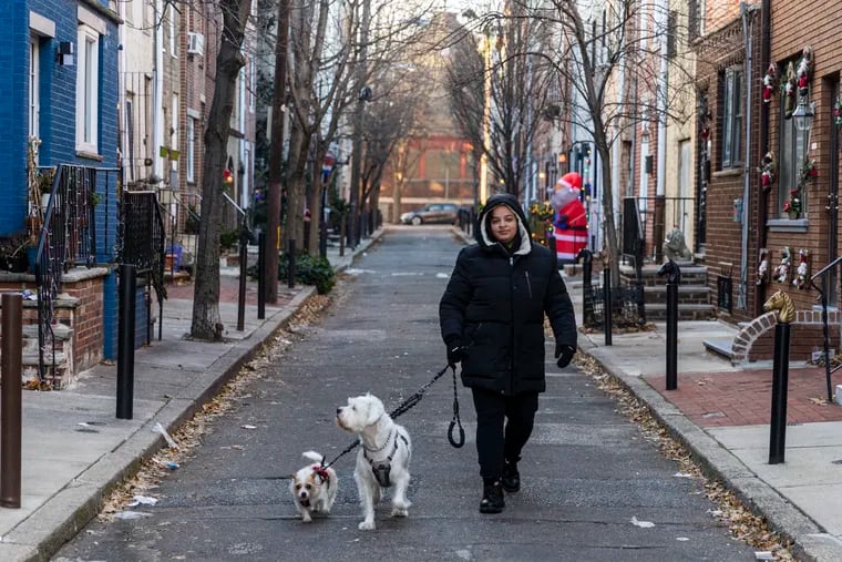 No matter how cold it is outside, the pups have to be walked. Mackenzie Benedict-Sager, of South Philadelphia, walked her dogs Kennedy and Coco around the Italian Market on Saturday.