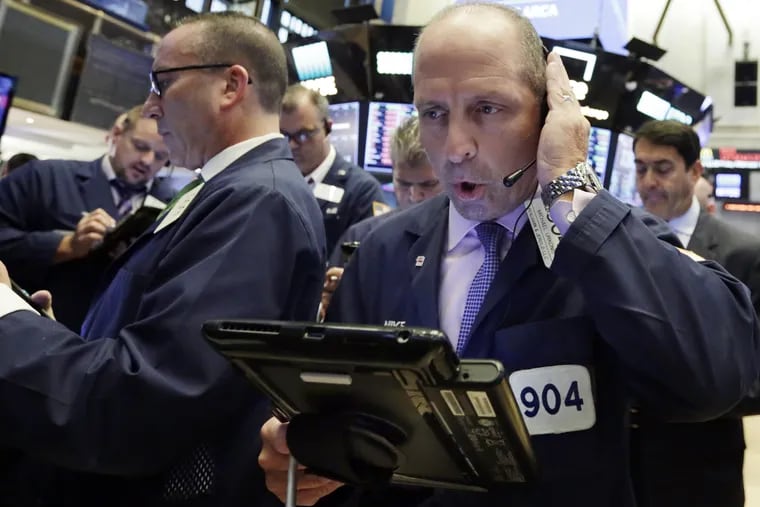 Trader Michael Urkonis, right, works on the floor of the New York Stock Exchange early this month. Most of the more than $1 trillion federal tax cut benefiting corporations went into stock buybacks, not raises for rank and file workers. ,