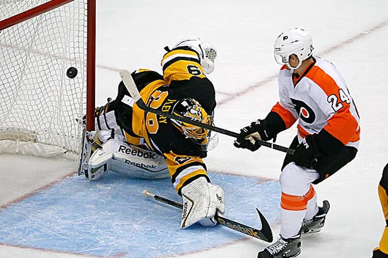 The Flyers' Matt Read backhands a shot over Penguins goalie Marc-Andre Fleury. (Gene J. Puskar/AP)