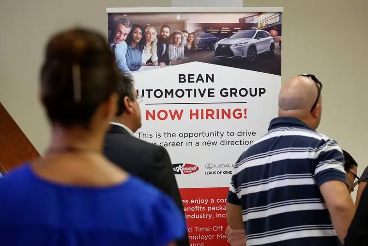 In this Sept. 18, 2019, file photo people stand in line to inquire about jobs available at the Bean Automotive Group during a job fair in Miami. On Friday, Jan. 10, 2020, the U.S. government issues the December jobs report.