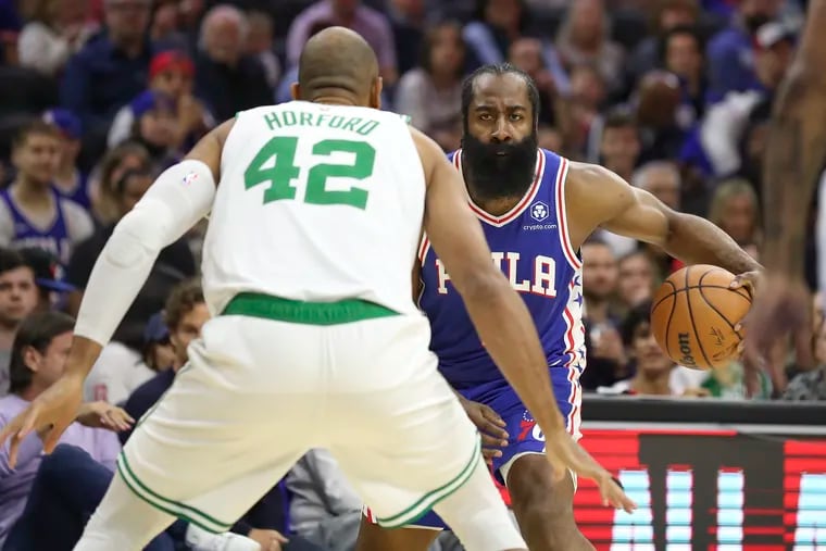 Philadelphia 76ers guard James Harden dribbles as Boston Celtics center Al Horford defends.