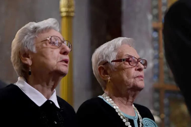 Bella Tugenreich and her sister Sara Weingram (right) during the Holocaust Remembrance Day observance at Rodeph Shalom They lighted one of six memorial candles during Philadelphia's annual ceremony for the six million Jewish martyrs.
