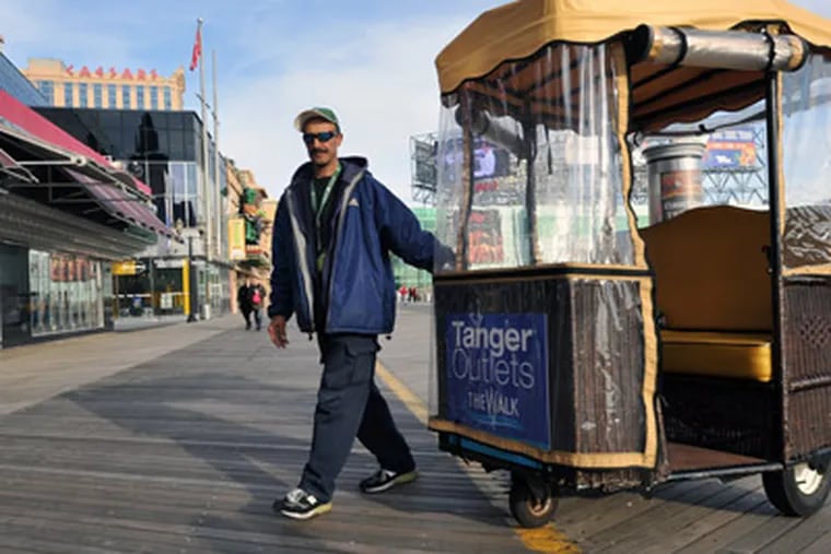 In a Monday Dec. 12, 2011 photo, Afghanistan native Muhammad Ranjabar works as a rolling chair operator on the Atlantic City boardwalk, in Atlantic City, N.J. Ranjbar was brought to America for medical treatment after he was injured fighting the Soviets in Afghanistan in the early 90s. Twenty years later, he's trying to return to his home country, but without paperwork from either country, he's in limbo.  (AP Photo/The Press of Atlantic City, Michael Ein)
