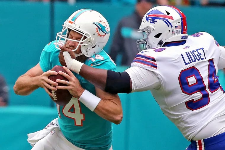 Miami Dolphins quarterback Ryan Fitzpatrick (14), who beat the Eagles last season for the Bucs, gets pulled by the facemask  by Buffalo Bills Corey Liuget in the first quarter at Hard Rock Stadium in Miami Gardens, Florida, Sunday, November, 17, 2019. (Charles Trainor Jr./Miami Herald/TNS)