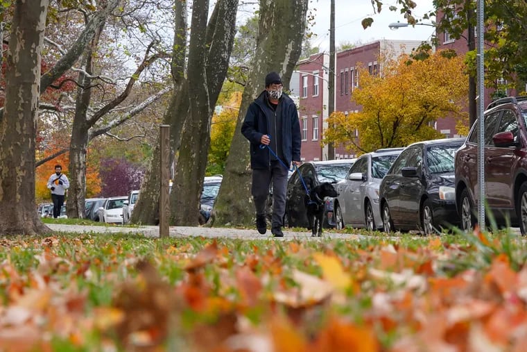 Christopher Hsieh walks his dog Petunia at Clark Park in Philadelphia. Sidewalks and proximity to parks are two amenities that pet owners seek when they decide where to live.