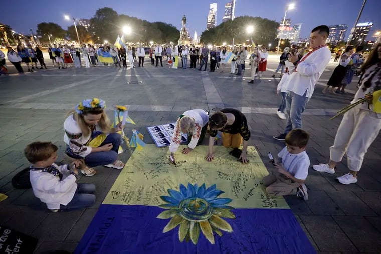 People wrote messages to Ukranians on a makeshift Ukranian flag that will be sent to Ukraine during a celebration of vyshyvanka, the traditional Ukrainian embroidery, and its importance as a symbol of a fighting Ukraine, on the Art Museum steps in Phila., Pa. on May 19, 2022.