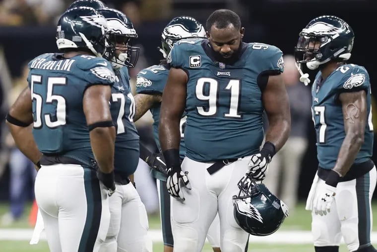Eagles defensive tackle Fletcher Cox looks down at his helmet against the New Orleans Saints on Sunday, November 18, 2018 in New Orleans. YONG KIM / Staff Photographer