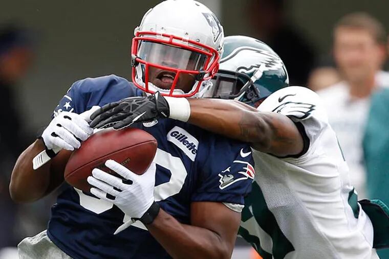 Patriots Josh Boyce (left) catches a pass in front of Eagles Eddie Whitley (right) during a joint Training Camp session at the NovaCare Complex in Philadelphia on August 7, 2013. (David Maialetti/Staff Photographer)