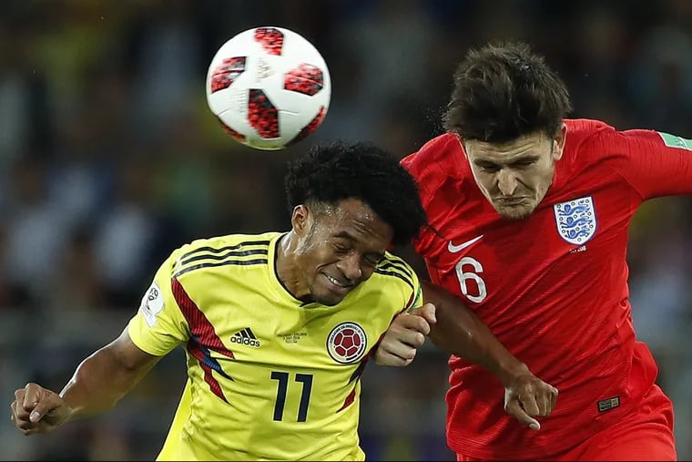 Colombia's Juan Cuadrado, left, and England's Harry Maguire fight for the ball during their round of 16 match in Moscow.