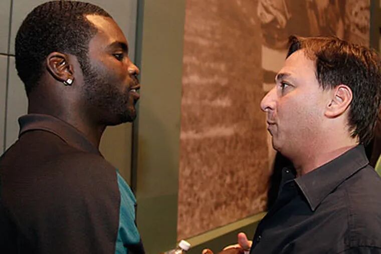 Michael Vick talks with his agent, Joel Segal, after yesterday's press conference at NovaCare. (David Maialetti/Staff Photographer)
