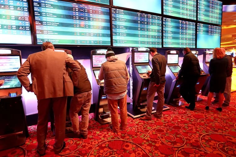 Bettors place sports wagers at some of the 26 kiosks installed throughout the Parx Casino in Bensalem, which took its first sports bets Tuesday.