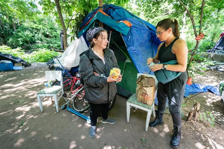 Draya LaMacchia (left) talks with homeless advocate and Villanova faculty member Stephanie Sena at a homeless encampment in Norristown.