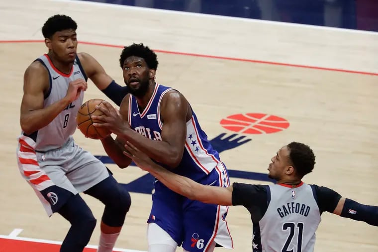 Sixers center Joel Embiid drives to the basket as Washington Wizards center Daniel Gafford falls back with forward Rui Hachimura in the first quarter during game three of their first round NBA playoff series in Washington on Saturday.