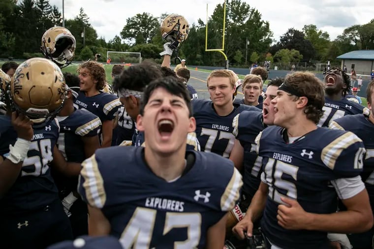 La Salle players raise their helmets and  celebrate with their fans after defeating Malvern Prep, 24-13, on Saturday, Sept. 7, 2019.