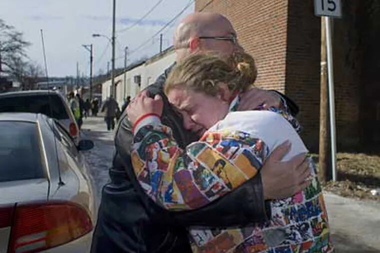 Neighbors John Wenger and Brandy Hickman embrace near their homes, which were destroyed by fire early Sunday morning in Coatesville. The fire destroyed 15 homes in the 300 block of Fleetwood Street. (Ed Hille / Staff Photographer)