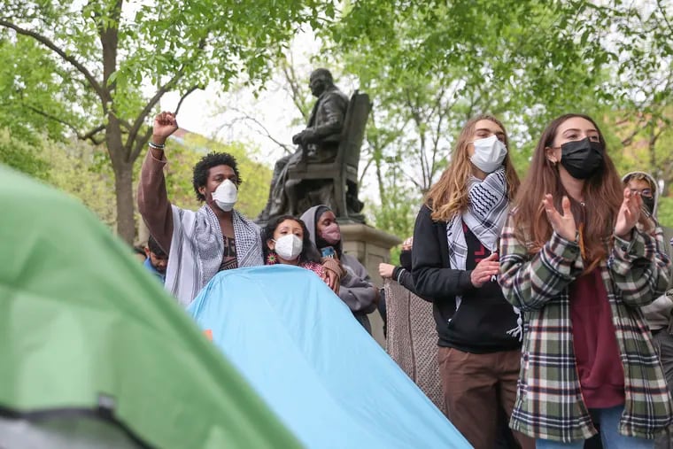 People in the encampment at University of Pennsylvania chant at College Green on Saturday. Tents remains up overnight despite an order to disband.