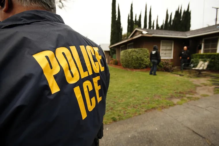 U.S. Immigration and Customs Enforcement agents are shown outside a San Fernando Valley, Calif. home in 2012.