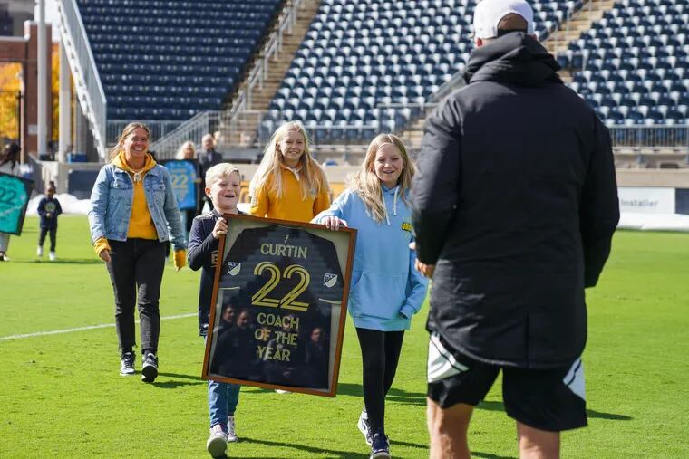 Union manager Jim Curtin (right) was presented with a commemorative jersey for winning Major League Soccer's 2022 coach of the year award by his wife and three children.