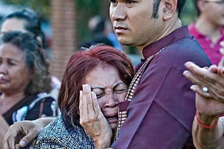 Sokhoeurn Kol, 55, Hov Ly Kol’s mother, cries in the arms of rally organizer David Seng on Independence Mall. (DAVID M WARREN / Staff Photographer)