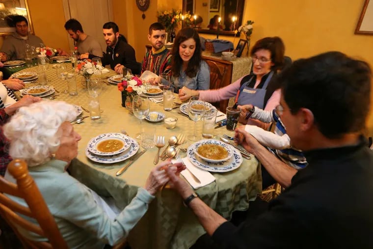 At Sunday supper with city managing director Michael DiBerardinis (right), the family gives thanks before diving into the Abruzzese five-course meal.