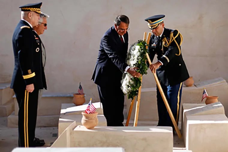 U.S. Secretary of Defense Leon E. Panetta (center) participates in the wreath-laying at the graves of U.S. sailors in Libya. (Pablo Martinez Monsivais / Associated Press, Pool)