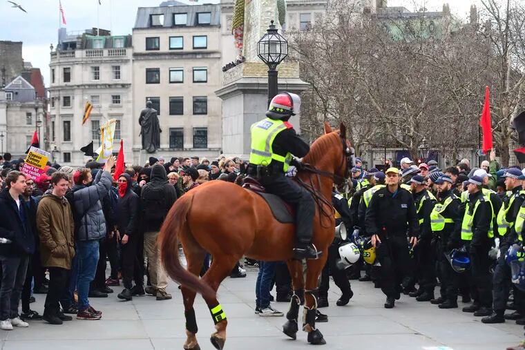 Police attempt to keep rival Brexit protest groups from clashing in central London, Sunday Dec. 9, 2018.  The "Brexit Betrayal Rally" led by English far-right activist Tommy Robinson and UK Independence Party, UKIP,  leader Gerard Batten, protesting for a split from Europe, and a Pro-Europe anti-fascist counter-demonstration both marched in central London. (Victoria Jones/PA via AP)