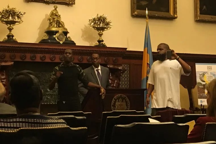 Asa Khalif (left) of Black Lives Matter Pennsylvania and Isaac Gardner (right) of the Justice for David Jones Coalition interrupt a news conference by Philadelphia Council President Darrell L. Clarke at City Hall.